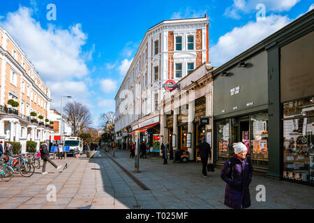 London, UK, 19. März 2018: Außenansicht des U-Bahnstation South Kensington an einem sonnigen Tag, mit Menschen zu Fuß auf der Straße. Stockfoto