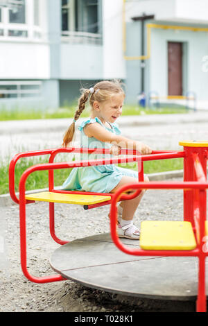 Kleines Mädchen Fahrt mit dem Karussell. Das Konzept der Kindheit, Lebensstil, Erziehung, Kindergarten Stockfoto