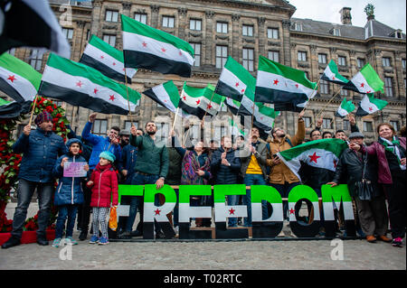 Amsterdam, Niederlande. 16. März 2019. Syrer gesehen Holding flags und ein Banner mit der Aufschrift Freiheit während der Demonstration. Die syrischen Gemeinde in den Niederlanden nahm den Platz Dam entfernt im Zentrum von Amsterdam für Freiheit und Menschenwürde zu verlangen nach 40 Jahren repressive Diktatur. Vor acht Jahren, fing eine Revolution in Syrien. Die Proteste ein Bürgerkrieg, der Millionen Vertriebenen hat, was zu einer der größten humanitären Flüchtlingskrise in der modernen Geschichte. Credit: SOPA Images Limited/Alamy leben Nachrichten Stockfoto