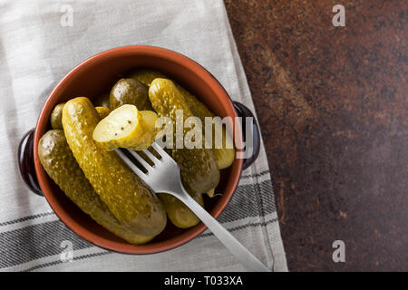 Eingelegte Gurken mit Senf und Knoblauch auf einem Stein Rusty Hintergrund. Stockfoto