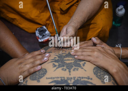 Nakhon Chaisi, Thailand. 16. März 2019. Ein Devotee erhält eine schützende Tattoo auf seinem Rücken während der jährlichen Wat Bang Phra Tattoo Festival in Nakhon Chaisi Bezirk, Thailand, etwa 50 km westlich von Bangkok, am 16. März 2019. Während Tausende von Thais Leute am Schrein im Wat Bang Phra Nakhon Chai Si Region versammelt, (ca. 50 km westlich von Bangkok), um zu sehen, den Wat Bang Phra Tattoo Festival Quelle: PACIFIC PRESS/Alamy leben Nachrichten Stockfoto