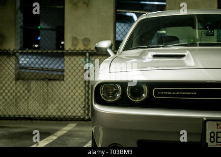 Eine Nahaufnahme eines modernen amerikanischen Muscle Car, der Dodge Challenger, dargestellt in einem städtischen Parkplatz suchen Stockfoto