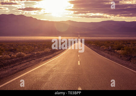 Fahrt in den Sonnenuntergang entlang CA-190 gerade östlich der Panamint Springs in Death Valley National Park, Kalifornien Stockfoto