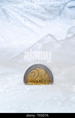 Zwei Euro Münze Teil in Eis ausgesetzt. Stockfoto