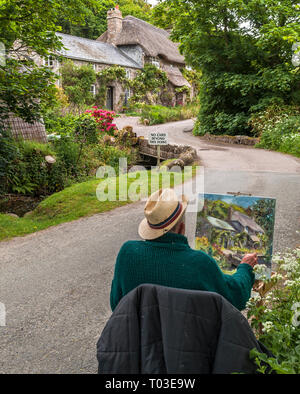 Ein Künstler Malerei eine hübsche Reetdachhäuser auf dem Weg zur Penberth cove West Cornwall UK Europa Stockfoto