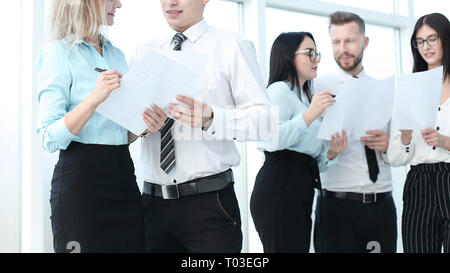 Gruppe von Mitarbeitern besprechen geschäftlicher Dokumente stehen im Büro Stockfoto