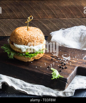 Hausgemachte fisch Burger auf einem dunklen Holz- Board. Stockfoto
