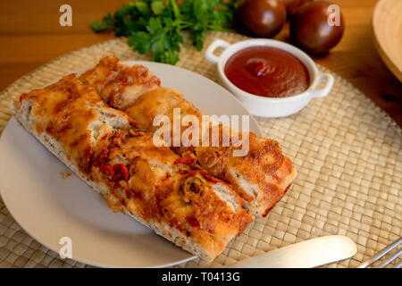 Hausgemachtes Brot im Ofen Focaccia mit Tomaten, Tomatensauce und Petersilie auf einem Teller, Ready-to-eat Stockfoto