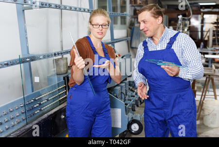 Nette Frau und ihr männlicher Kollege arbeitet in der gläsernen Werkstatt Stockfoto