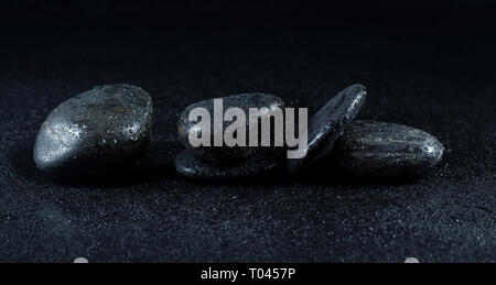 Zen Steine mit Tautropfen auf schwarzem Hintergrund Stockfoto