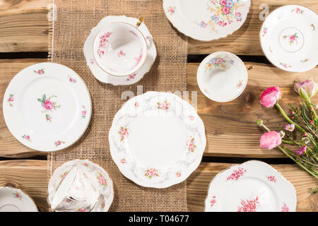 Alte romantische Porzellan, rosa Blüten auf rustikale Holzplanken angeordnet. Von oben, flach Schuß. Stockfoto
