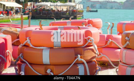 Orange rauszuschwimmen gestapelt auf dem Boot in Zattere Hafen, wo das schwimmende Restaurant auf der Rückseite gesehen Stockfoto