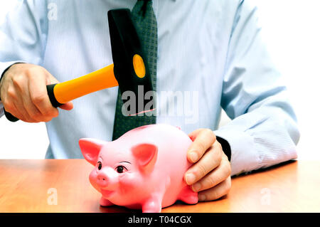 Den Menschen ein Sparschwein mit Hammer Stockfoto