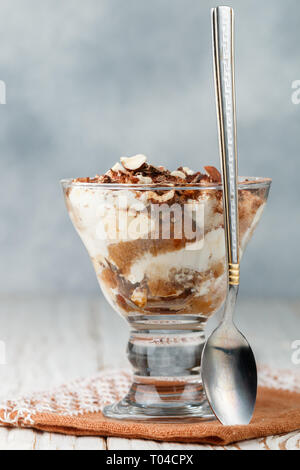 Kleinigkeit. Hausgemachte Layered Dessert aus Keks und Frischkäse (Mascarpone oder Joghurt) mit Schokolade und Nüsse in ein Glas. Tiramisu. Käsekuchen. Sel Stockfoto