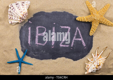 Handschriftliche Wort Ibiza mit Kreide geschrieben, unter Muscheln und Seesterne. Ansicht von oben Stockfoto