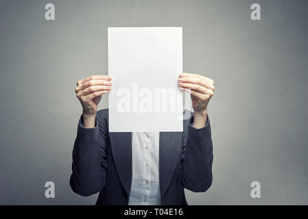 Anonyme business Frau in weißer Bluse und Klage über das Gesicht mit weißem Blatt Papier Stockfoto