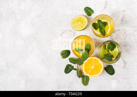 Citrus detox Drinks oder Cocktails mit Minze und Scheiben von Obst. Stockfoto