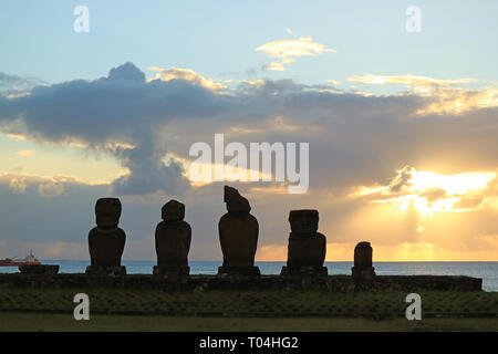 Silhouette der Moais am Ahu Tahai zeremoniellen Plattform gegen Sonnenuntergang über dem Pazifischen Ozean, Archäologische Stätte auf der Osterinsel, Chile Stockfoto