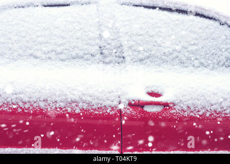 Auto im Schnee. Die Fenster des Autos sind mit Schnee bedeckt Stockfoto