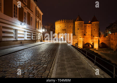 Podwale Straße mit Kopfsteinpflaster und beleuchtete Barbican in der Nacht in der Stadt Warschau in Polen. Stockfoto