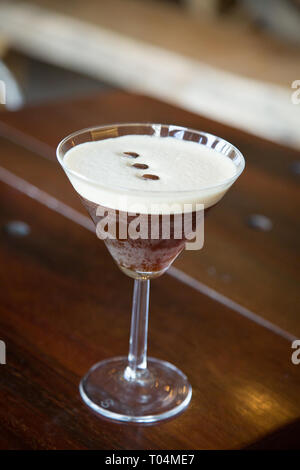 Eisige Espresso Martini auf Bar mit Coffee Bean garnieren Stockfoto