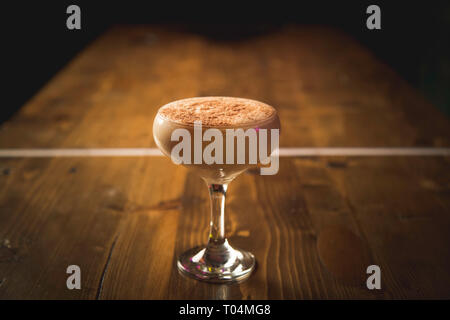 Cremiger Cocktail in Glas auf der Holzbank Stockfoto