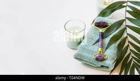 Spa noch Leben mit Amethyst Roller, Kerze, Handtuch und grün Blatt Pflanze, spa und wellness Einstellung Stockfoto