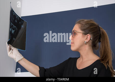 Junge Ärztin in einem x-ray in private Beratung suchen Stockfoto