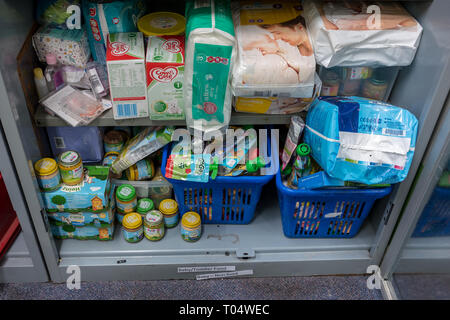 Ablagen in einem britischen Trussell Vertrauen lokalen Kirche food bank Lager zeigen, Babynahrung, Pflegeprodukte, Milch und Windeln für Lebensmittelpakete bereit Stockfoto