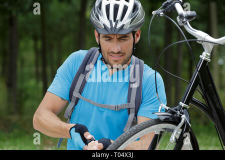 Man pumpt ein Fahrrad Rad auf der Straße Stockfoto