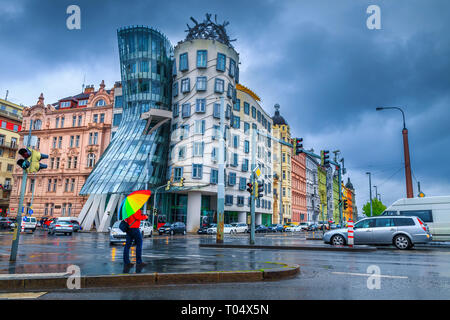 Touristische Menschen mit regenbogenfarbenen Regenschirm in einem verregneten Tag an der Kreuzung in der Nähe der berühmten Tanz House, Prag, Tschechische Republik, Europa Stockfoto