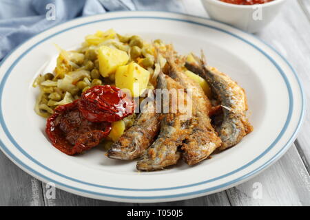 Chicharros fritos, traditionelle Portugal gebratene panierte Stöcker Fische mit Kohl, Kartoffeln und Erbsen Eintopf Stockfoto