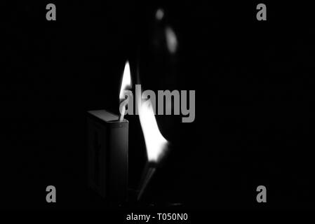 Schachtel Streichhölzer mit zwei Treffern gegen einen dunklen Hintergrund beleuchtet. Stockfoto