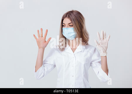 Portrait von Frau Doktor mit Gesichtsmaske Arzt Hände zeigt. Eine behandschuhte Hand und die anderen ohne Stockfoto