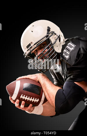 Portrait von American Football Spieler mit einem Ball mit beiden Händen Stockfoto