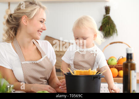 Glückliche Mutter und Tochter Kochen in der Küche. Ausgabe Zeit alle zusammen, Familie Spaß Konzept Stockfoto