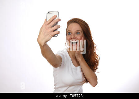 Schöne rothaarige Frau nimmt eine selfie mit Ihrem Mobiltelefon Stockfoto