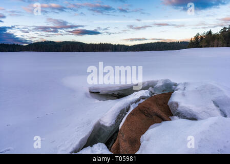 Morgen in die Berge. Unten auf dem gefrorenen See Shiroka poliana bedeckt mit Schnee in den Rhodopen Gebirge, Bulgarien Stockfoto