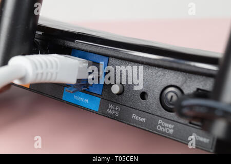 Nahaufnahme eines modernen WLAN-Router mit angeschlossenen Kabel Internet auf weißem Hintergrund. Stockfoto
