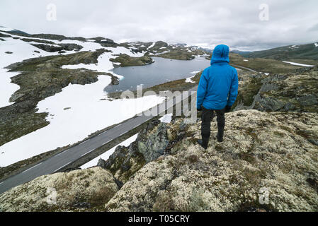 Norwegische touristische Route Aurlandsfjellet läuft von aurlandsvangen zu Laerdalsoyri. Bjorgavegen - Mountain Road in Norwegen. Ein Kerl steht auf einem Hügel ein Stockfoto