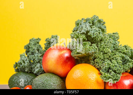 Frisches rohes Gemüse und Obst. Das gesunde Essen Hintergrund mit Orangen, Äpfel, Grünkohl, Brokkoli, Orangen, Tomaten, Avocados Stockfoto