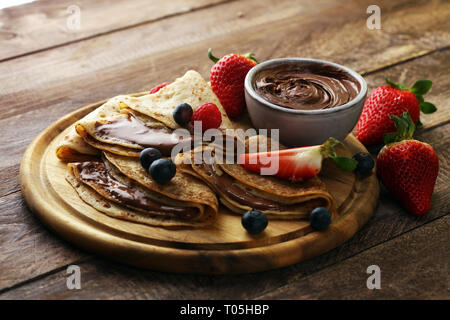 Lecker lecker hausgemachte Pfannkuchen mit Schokolade oder Pfannkuchen mit Himbeeren und Blaubeeren auf Holz Stockfoto