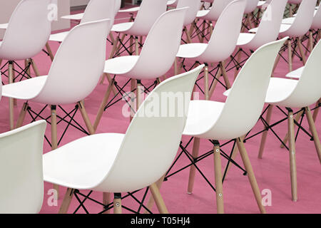 Konferenz weißen Stühlen in Business Zimmer, Zeilen aus weißem Kunststoff komfortable Sitze in Leer Corporate Presentation Konferenz Büro, Detail, selektive fo Stockfoto