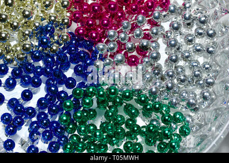 Traditionelle drei Farbe Mardi Gras Perlenketten auf einem weißen Kristall Glas Hintergrund Stockfoto