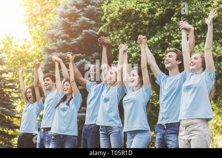 Melden Sie Gruppe von jungen Freiwilligen Hände in Park Stockfoto