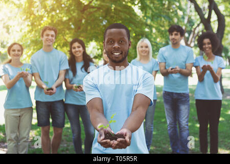 Gruppe von Freiwilligen mit Bäumen für wachsende Stockfoto