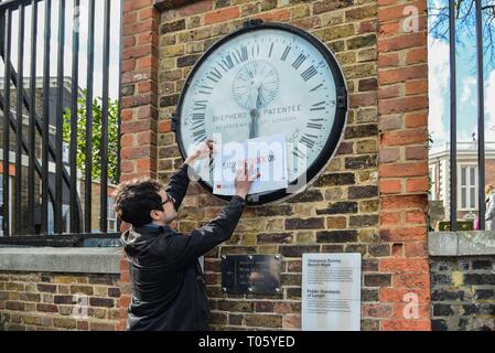 London, Großbritannien. 17 Mär, 2019. Aktivist Andreas Pisauro legt'S top Die Uhr auf Brexit' Schild Greenwich Wecker neben dem Greenwich Meridian line. Eine britische Druck Gruppe namens "Machen Sie eine Pause vom Brexit und Neue Europäer Irland Protest in Greenwich Park die Heimat von GMT. Eine nationale Kampagne, Gruppe, die gerne Brexit um mindestens ein Jahr verschoben. Credit: Claire Doherty/Alamy leben Nachrichten Stockfoto