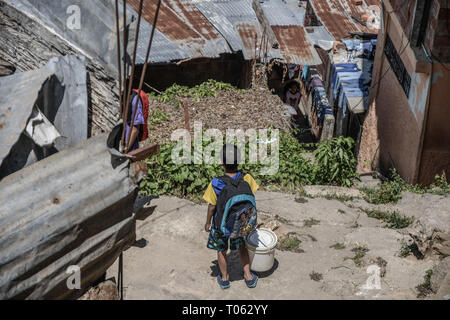 Caracas, Venezuela. 16 Mär, 2019. Ein Kind mit einem Eimer Wasser während der Schwarzen heraus gesehen. das Fehlen von Wasser die Lebenshaltung in Venezuela betroffen waren, die Situation verstärkt nach einer nationalen Blackout, dass 3 Tage dauerte. Die Dienstleistungen sind stark betroffen. In Petare, einer der größten schlechte Sektoren in Lateinamerika, haben sie für mehr als 30 Tage ohne Wasser gegangen. Credit: Roman Camacho/SOPA Images/ZUMA Draht/Alamy leben Nachrichten Stockfoto