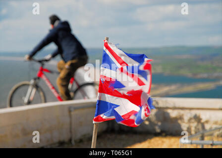 Chesil Beach, UK. 17 Mär, 2019. Ein tattered Britische Flagge (Union Jack) fliegt auf einem sonnigen, auf einer Klippe, in der starke westliche Winde weht über Chesil Beach, Isle of Portland Credit: stuart Hartmut Ost/Alamy leben Nachrichten Stockfoto