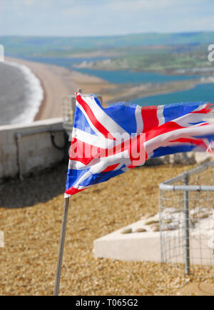 Chesil Beach, UK. 17 Mär, 2019. Ein tattered Britische Flagge (Union Jack) fliegt auf einem sonnigen, auf einer Klippe, in der starke westliche Winde weht über Chesil Beach, Isle of Portland Credit: stuart Hartmut Ost/Alamy leben Nachrichten Stockfoto